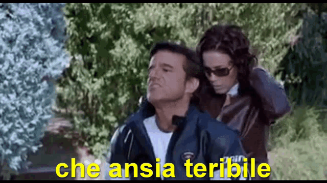a man and a woman are standing next to each other with the words che ansia terribile written in yellow