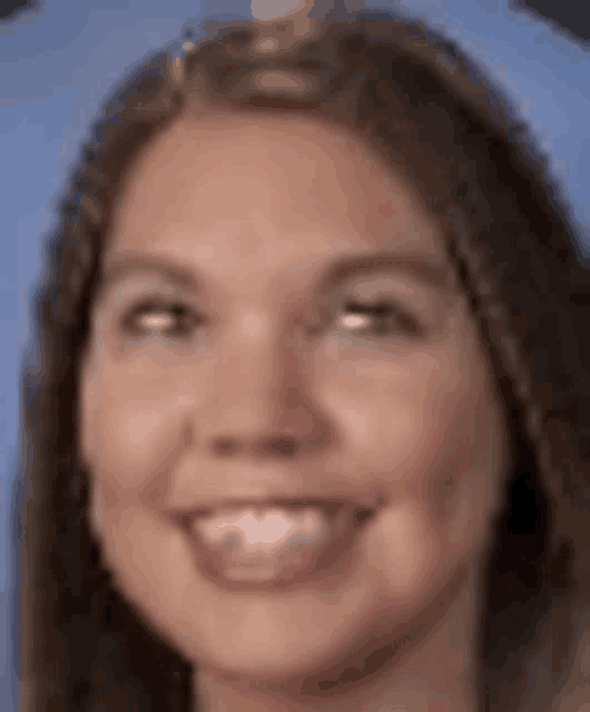 a close up of a woman 's face with a blue background and a smile .