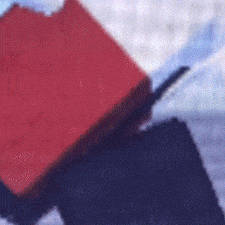 a red box is sitting on top of a black box on a table