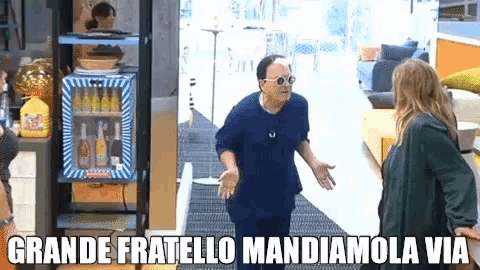 two women are standing next to each other in front of a fridge with the words grande fratello mandiamola via written on it .