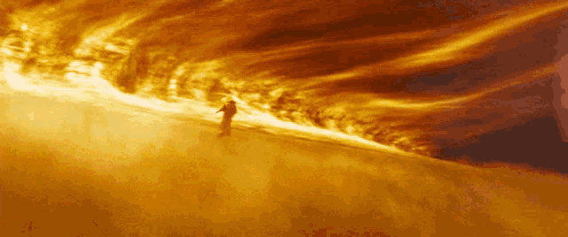 a person is standing in front of a bright orange fire