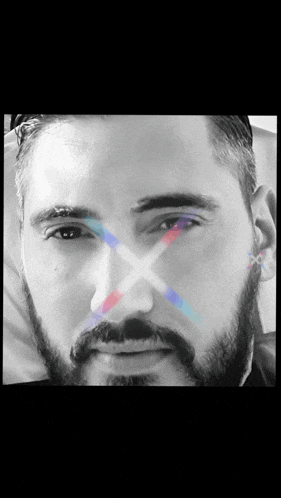 a close up of a man 's face with an x in the middle of his eye