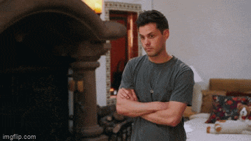 a man stands with his arms crossed in front of a fireplace with imgflip.com written below him