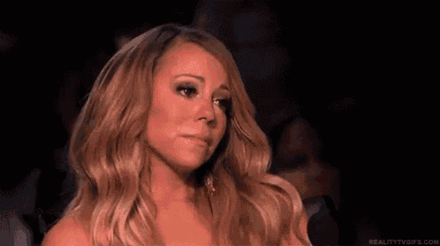 a woman with long blonde hair is crying while sitting in a chair .
