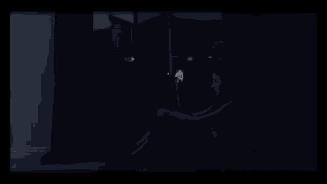 a person sitting in a dark room holding a lit candle