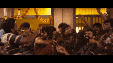 a group of men are standing in a room with their hands in the air .