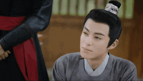 a man with a crown on his head is looking at something
