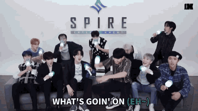 a group of young men sitting on a couch in front of the spire entertainment logo