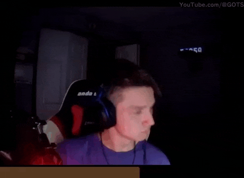 a man wearing headphones and a purple shirt is sitting in a chair .