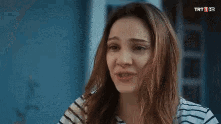 a woman in a striped shirt is crying and looking at another woman .