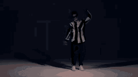 a man in a black and white striped shirt is dancing in front of a dollar bill .