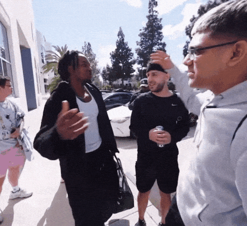 a group of men standing on a sidewalk talking