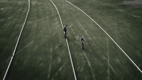 two men standing on a soccer field with a few lines