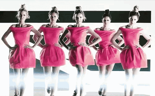 four women in pink dresses are standing next to each other