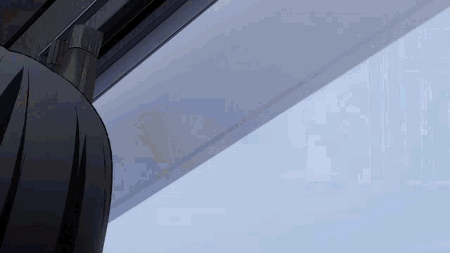 a person is standing in front of a window with a blue sky behind them