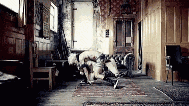 a man is kneeling on the floor in a room with a couch