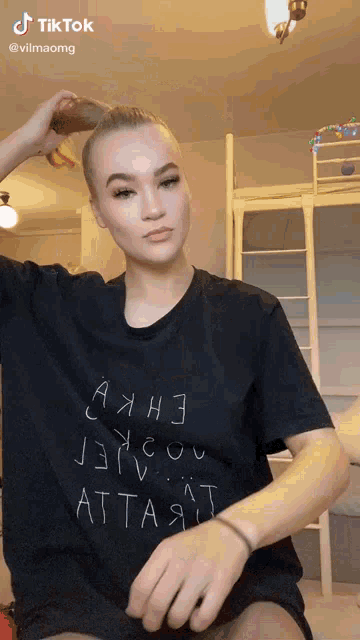 a woman wearing a black t-shirt that says attaa on it