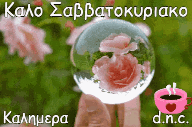 a person is holding a glass ball with flowers in it and a cup of coffee