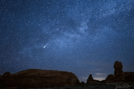 a starry night sky with a shooting star in the foreground