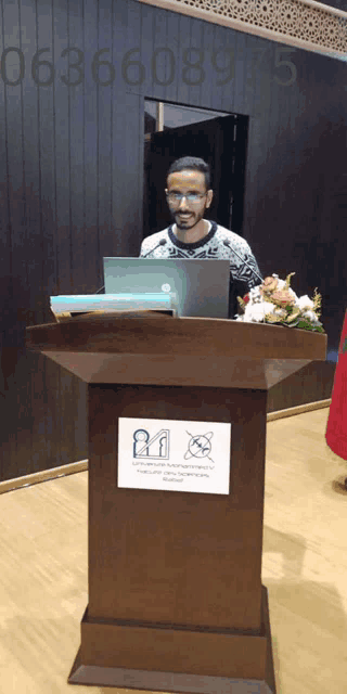 a man stands behind a podium with a sign on it that says " no smoking "