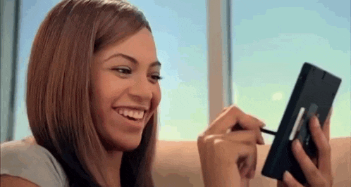 a woman is sitting on a couch looking at herself in a mirror .