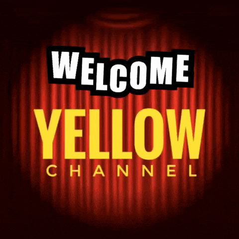 a welcome yellow channel sign with a red curtain behind it