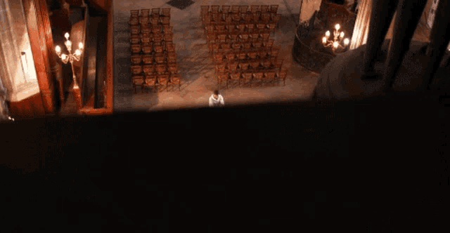 a man sits at a podium in a church with rows of chairs