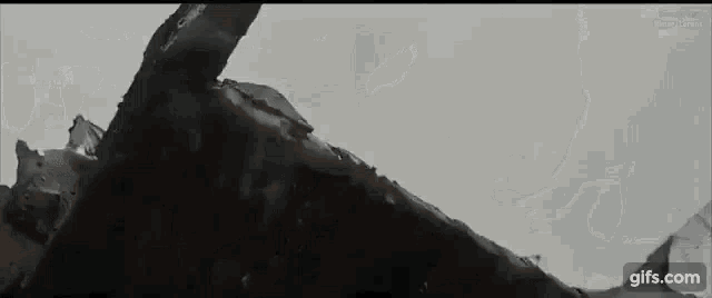 a close up of a person laying on top of a pile of rocks .