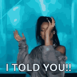 a woman is dancing in front of a blue background and says `` i told you ! ''
