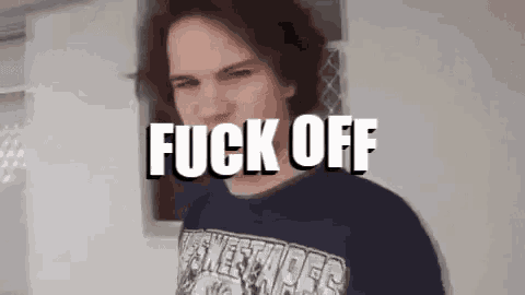 a man in a blue shirt is standing in front of a sign that says " fuck off "