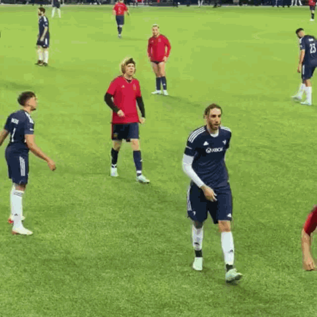 a group of soccer players on a field one of whom is wearing a jersey that says xbox