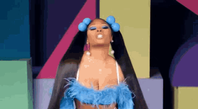 a woman with curlers in her hair is wearing a blue feathered top and a black jacket .