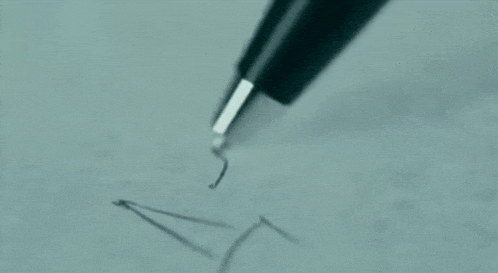a person is writing on a piece of paper with a pen and eraser .