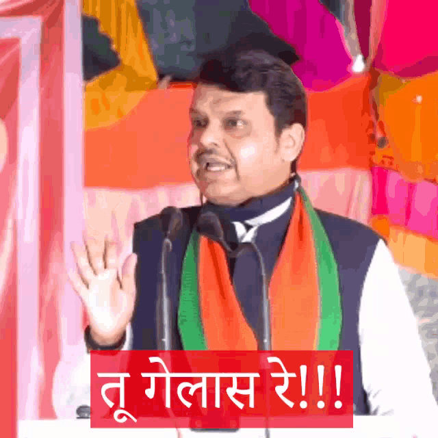 a man is giving a speech with a sign that says ' t golas re !! ' on it