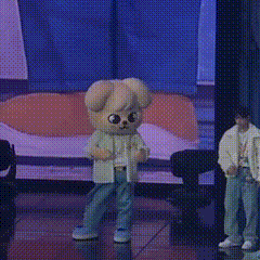 a mascot is standing on a stage with a man standing behind him