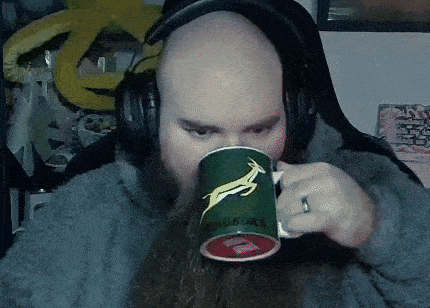 a man with a beard is drinking from a green mug that says ringboks