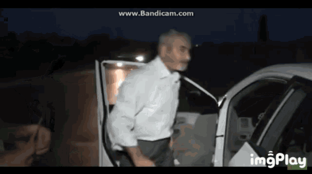 a man is getting out of a car with imgplay written on the bottom