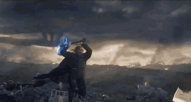 thor is holding a hammer in his hand in the middle of a field .