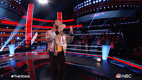 a man singing on a stage with a nbc logo on the bottom