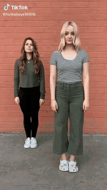 two women are standing next to each other in front of a red brick wall with tiktok written above them