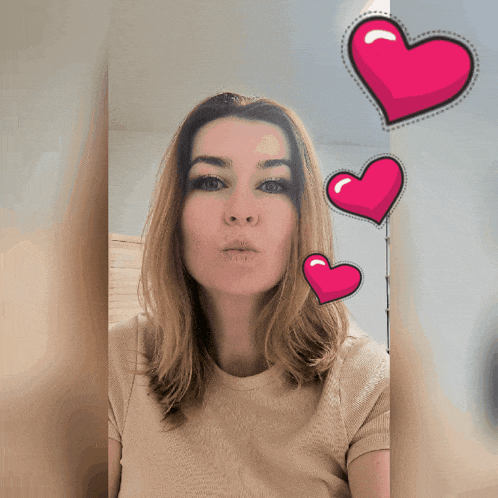 a woman blowing a kiss with three hearts around her head