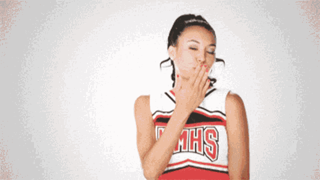 a cheerleader blowing a kiss wearing a mhs jersey