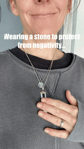a woman is wearing a stone necklace to protect her from negativity