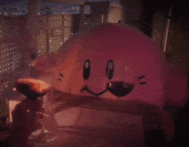 a person is holding a glass of wine in front of a stuffed animal that looks like kirby