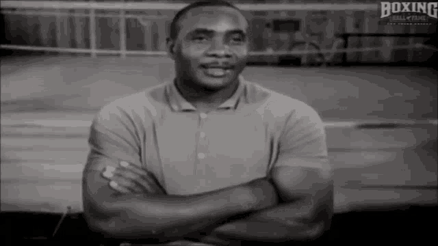 a black and white photo of a man with his arms crossed and the words boxing hall of fame behind him
