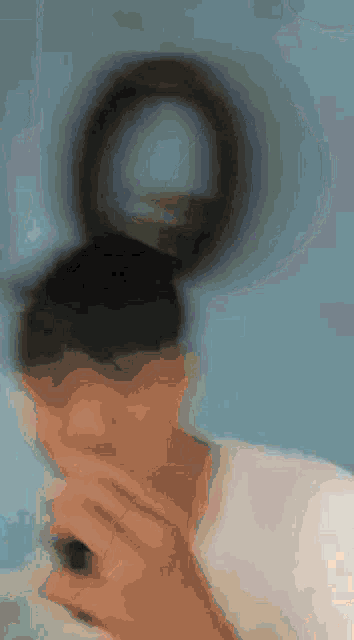 a blurry picture of a person holding a magnifying glass in their hand .