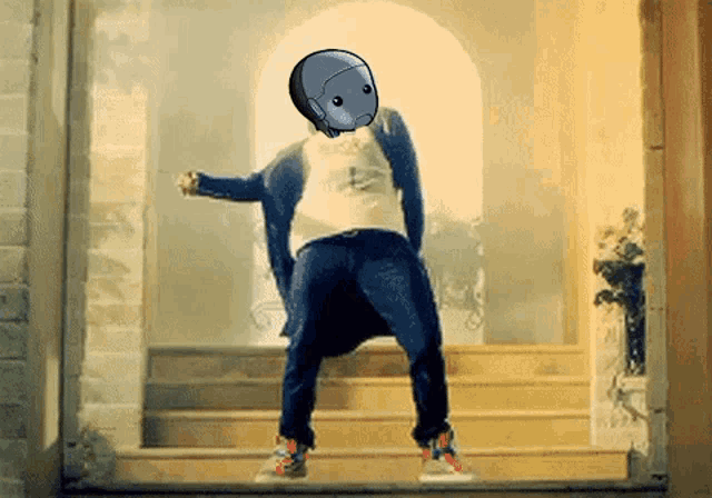 a man with a robot head on his head is dancing on stairs