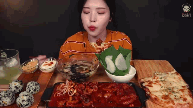 a woman is sitting at a table eating a variety of foods