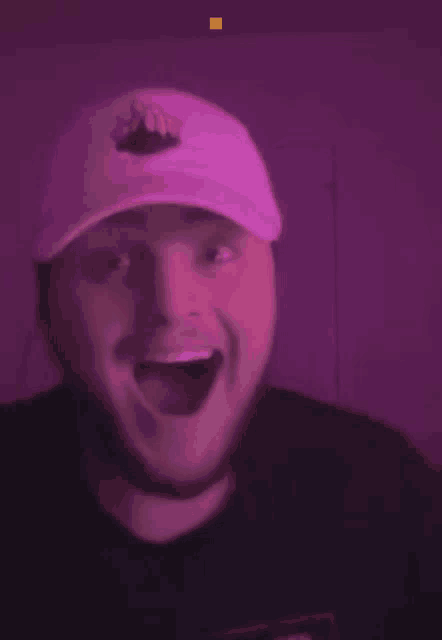 a man wearing a hat with a crown on it is making a funny face