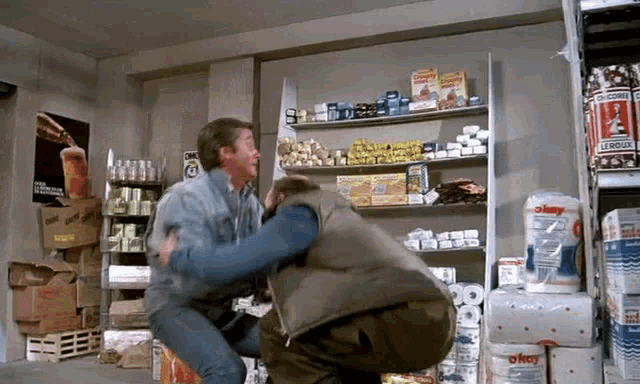 two men are fighting in a store with a sign that says coca cola
